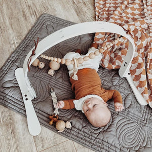 Baby boy playing on quilted playmat 