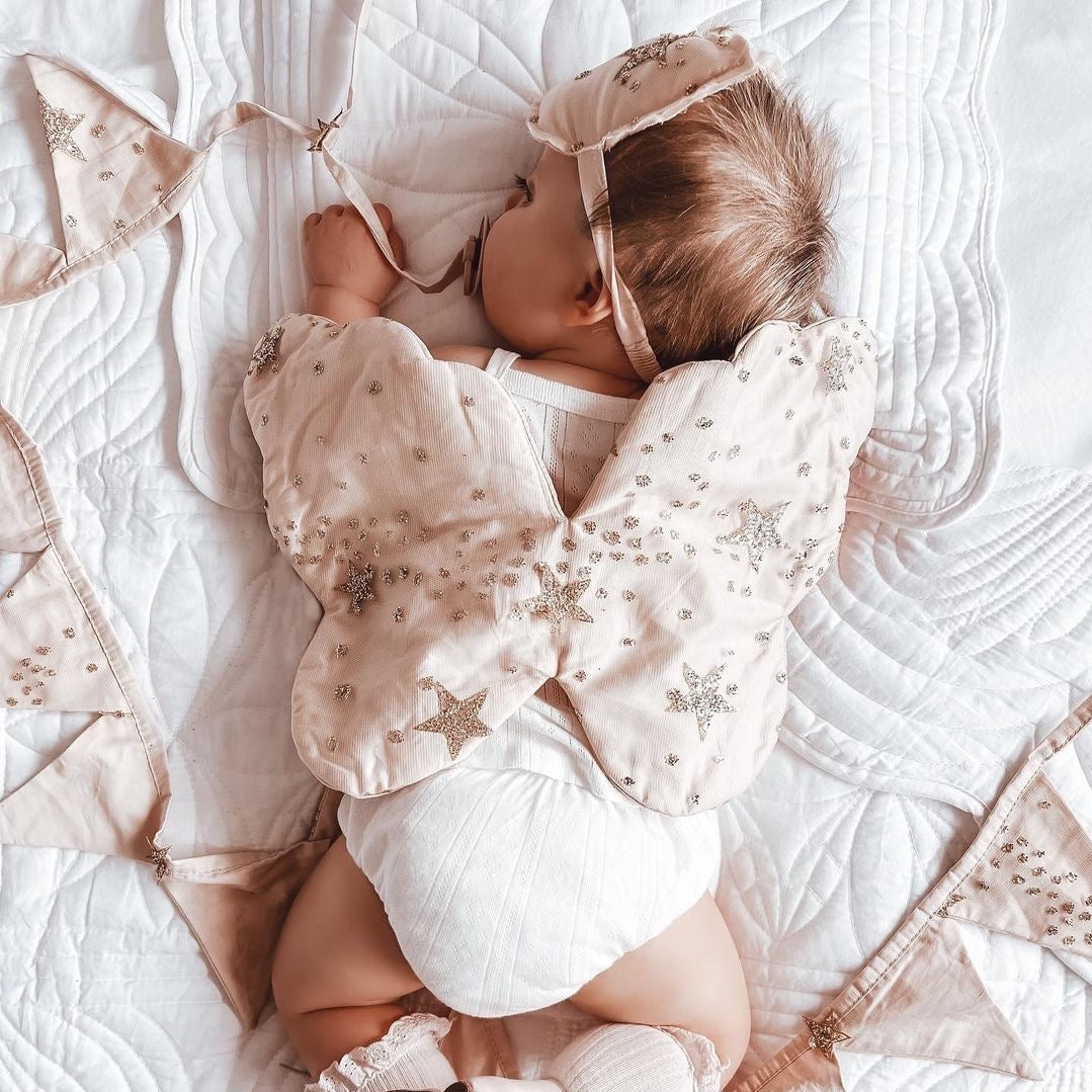baby girl wearing her glitter star angel wings