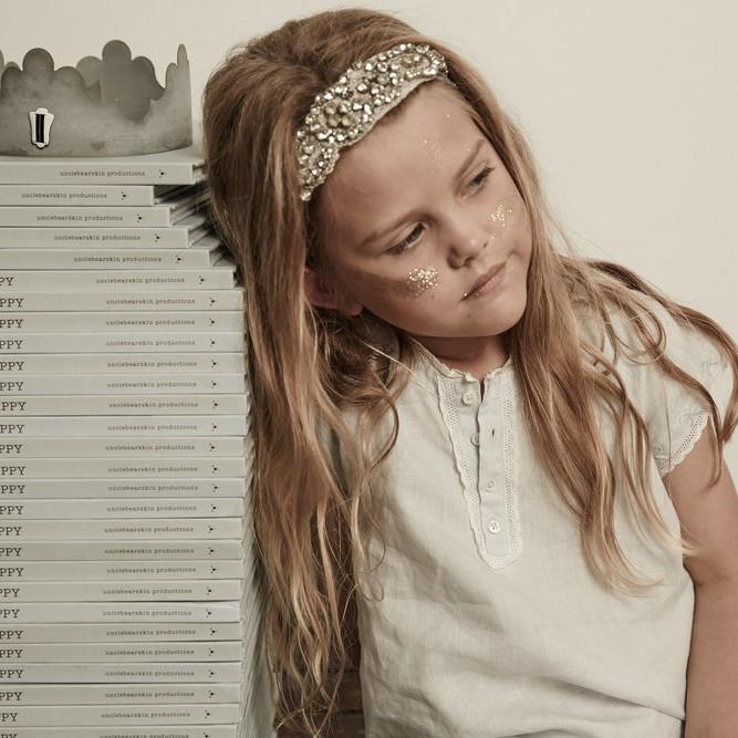 Little girl day dreaming in mist blue linen nightie